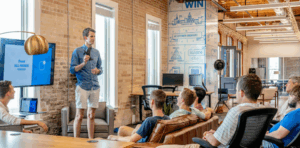 Man presenting to an audience in a modern office setting, discussing digital marketing strategies and insights.