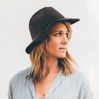 Woman wearing a hat, looking thoughtfully to the side, representing the creative and professional team behind Star Digital Strategies' digital marketing and website design services.